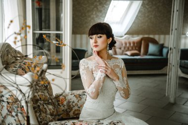 güzel bir odada bir kanepede oturan gelin