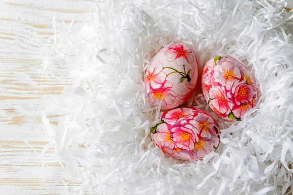 Прикрашені розфарбованими великодніми яйцями та квітами на світлому фоні — стокове фото