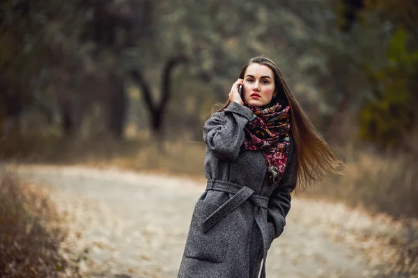 젊은 아름 다운 소녀는 공원에서 산책 하는 휴대 전화 — 스톡 사진