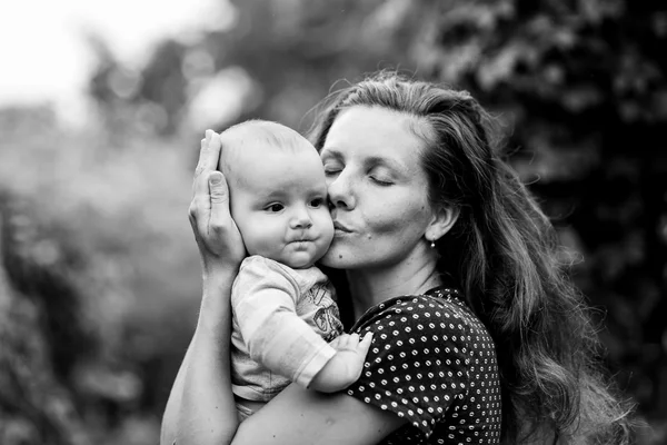 Мать обнимает и целует его маленького сына — стоковое фото