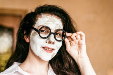 komik genç kadın bir derin temizlik kil maskesi uygulama