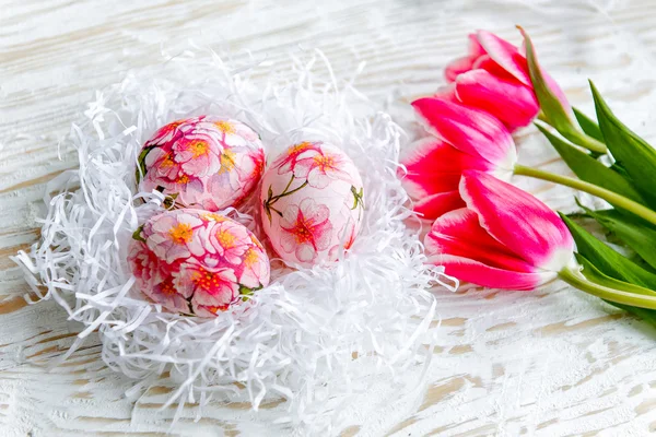 Decorado com ovos de Páscoa pintados e flores em um fundo leve — Fotografia de Stock