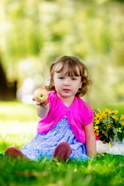 Schattige kleine meisje eten apple in het park — Stockfoto