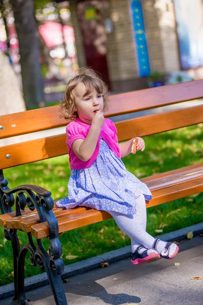 Niña come galletas en el parque — Foto de Stock