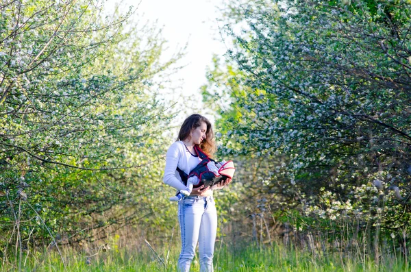 꽃 정원에서 그녀의 젊은 어머니와 작은 아기 — 스톡 사진