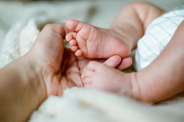 Nogi u noworodka w ręce matki — Zdjęcie stockowe