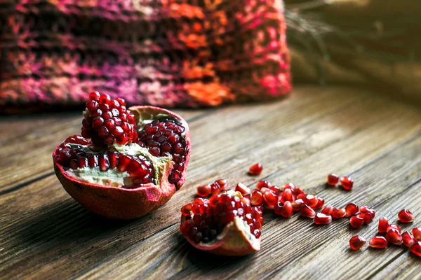 Fruta de granada madura con rodajas de granada en un primer plano de mesa de madera . — Foto de Stock