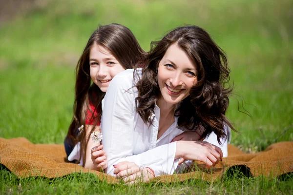 Hija con la madre sentada en la hierba y hablando — Foto de Stock