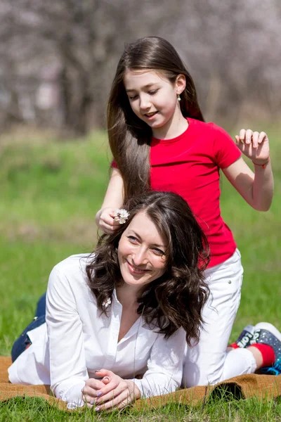 Filha com a mãe sentada na grama e falando — Fotografia de Stock
