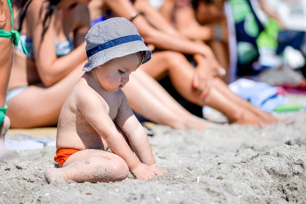 Kumsalda kumsalda oturan küçük çocuk. — Stok fotoğraf
