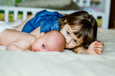 Evde yatakta yatıyordu sevimli küçük kız kardeşi ile oynuyor 