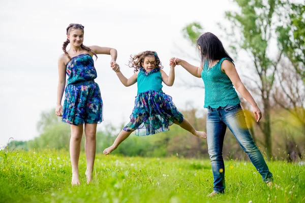 Frumoasa femeie tânără cu doi copii în parc . — Fotografie, imagine de stoc