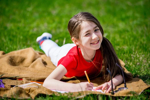 Hermosa niña dibuja en lápices de la naturaleza — Foto de Stock