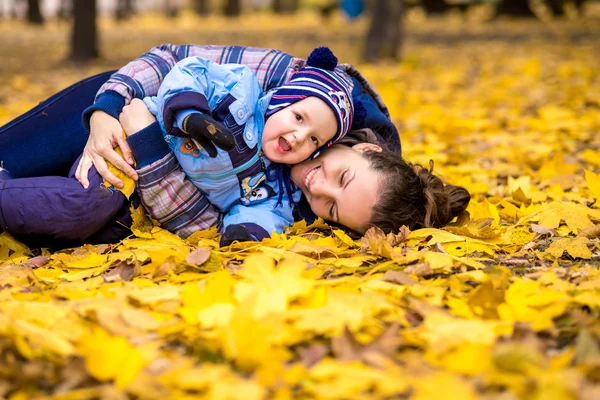 秋の公園で彼女の小さな息子と幸せな若い美しい母 — ストック写真