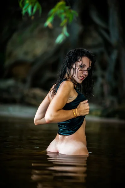 Young sexy girl stands in the water at sunset. — Stock Photo, Image