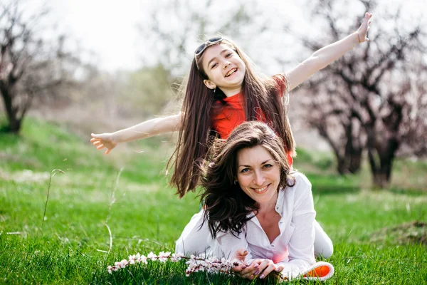 草の上に座って、話母と娘 — ストック写真