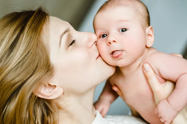 Família feliz mãe e bebê se divertindo jogando, beijando na cama — Fotografia de Stock