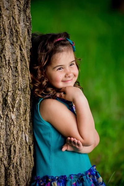 Linda menina com cabelo encaracolado na natureza, sorriso ensolarado — Fotografia de Stock