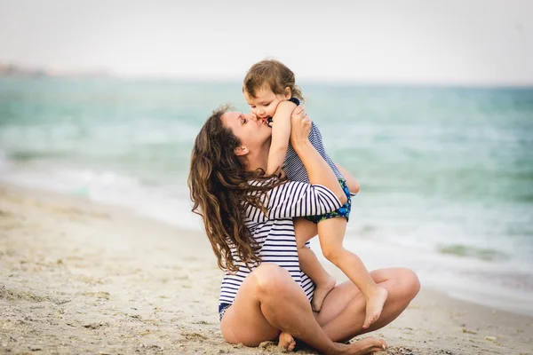 Jonge mooie moeder en haar aanbiddelijke Zoon plezier op het strand. — Stockfoto