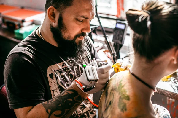 Il processo di creazione di un tatuaggio sul retro di una ragazza — Foto Stock