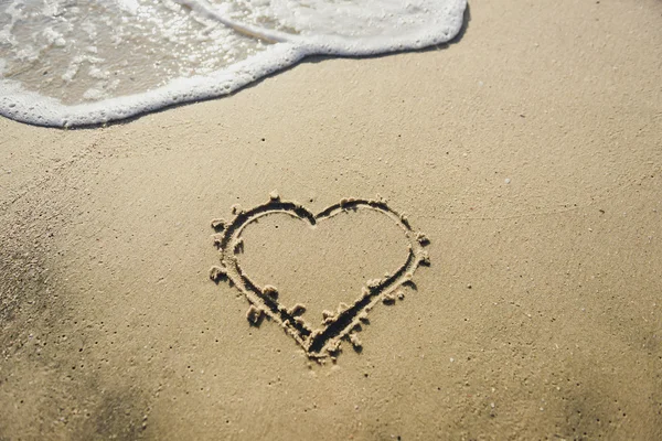 Heart on the sand beach. Conceptual love Stock Image