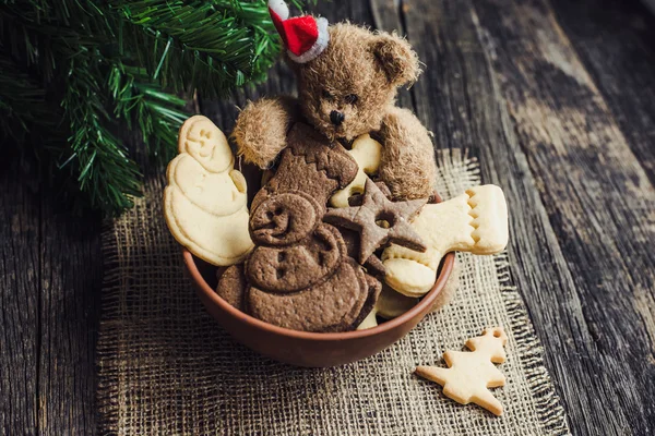 Biscotti a tema natalizio in un piatto e un orsacchiotto — Foto Stock