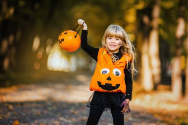 Mutlu Cadılar Bayramı Parkta sepeti olan sevimli küçük cadı