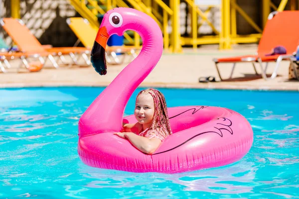 Menina nada em um flamingo inflável — Fotografia de Stock