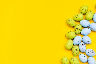 Sarı kağıttan arkaplanda renkli paskalya yumurtaları