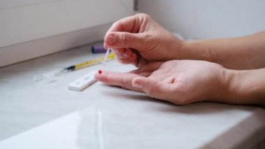 Coronavirüs, COVID 19 'u belirlemek için evde hızlı bir test yapan bir kadın.