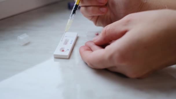 Μια γυναίκα που κάνει ένα γρήγορο τεστ στο σπίτι για να καθορίσει το coronavirus, COVID 19 — Αρχείο Βίντεο