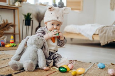Elinde Paskalya yumurtası olan tavşan kostümlü komik çocuk. Paskalya kutlaması
