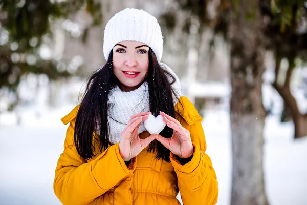 Coração de neve nas mãos de uma menina — Fotografia de Stock