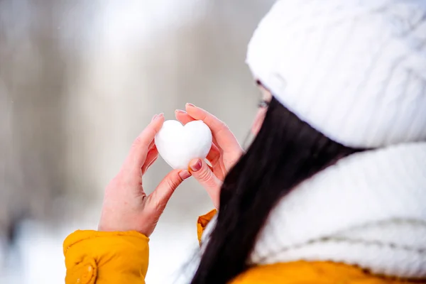 Серце снігу в руках дівчини — стокове фото