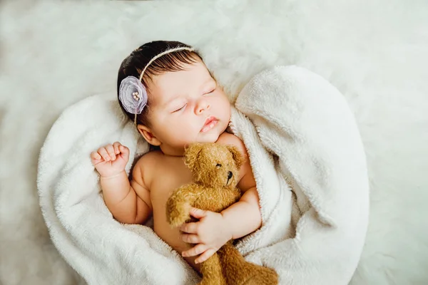 Újszülött baba lány alszik csomagolva a fehér takaró. — Stock Fotó