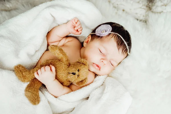 Newborn baby girl sleeps wrapped in white blanket. — Stock Photo, Image