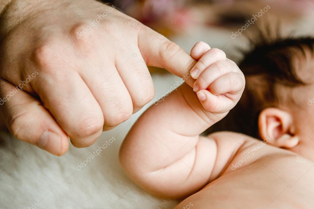 Newborn baby hand holding dads finger Stock Photo by ©Lakschmi 99674088