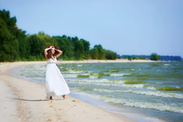 Chica joven en la playa en un vestido blanco — Foto de Stock