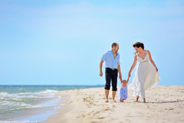 Anne, baba ve oğul sahil üzerinde vardır