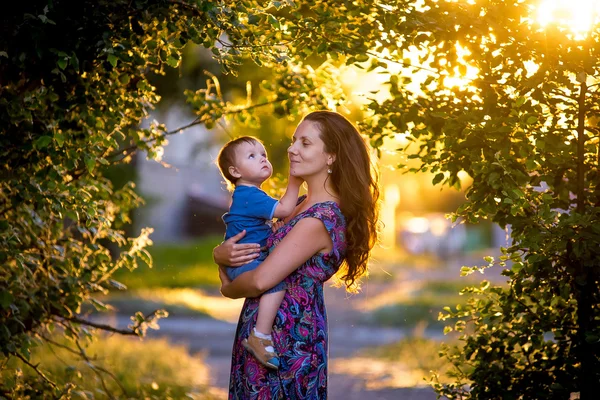 Por do sol mãe com seu filho em seus braços — Fotografia de Stock