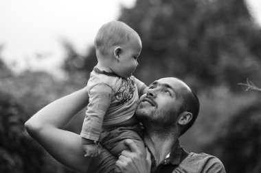 Babalar omuz ve gülümseyen çocuk oturur