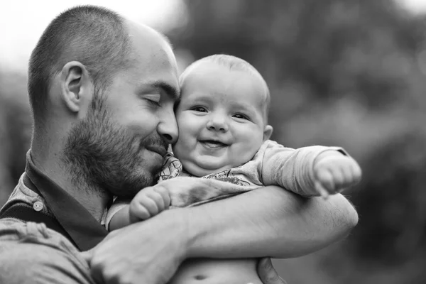 Niño se sienta en el hombro de los papás y sonríe — Foto de Stock