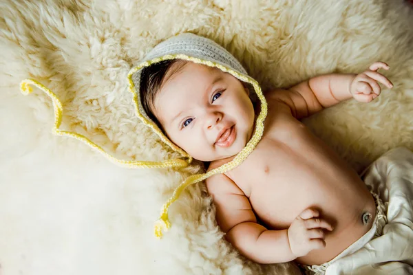 Bebé con un sombrero blanco de punto bebé en la espalda — Foto de Stock