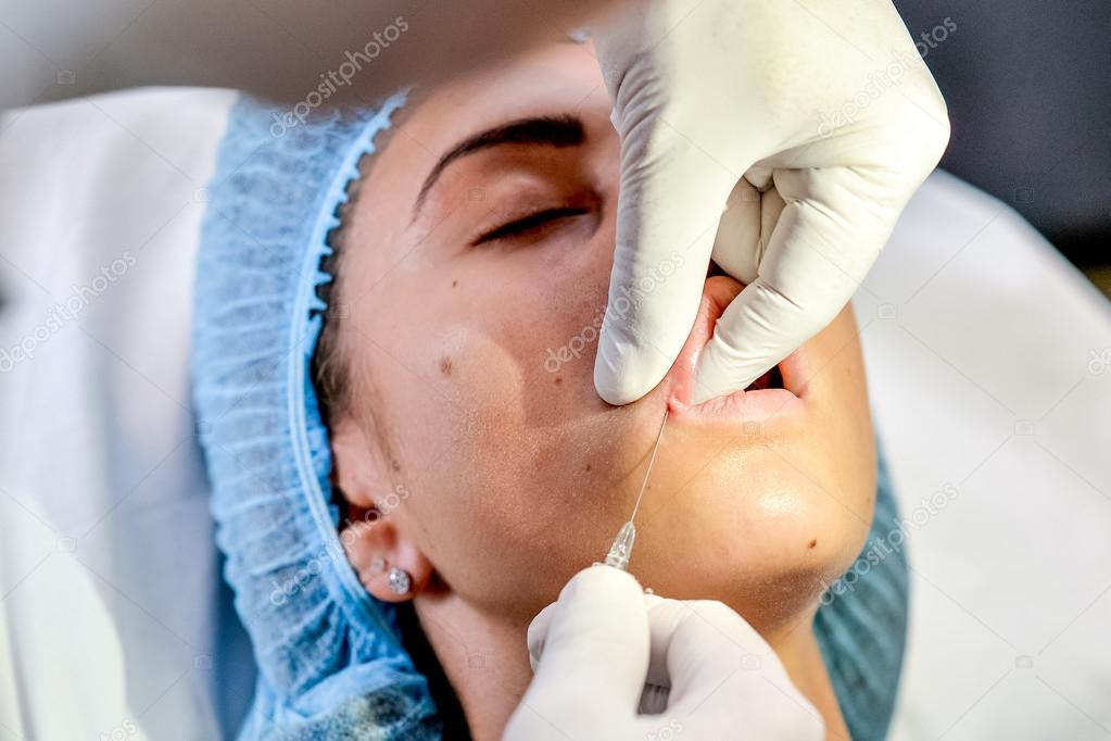 Young Woman Gets an Injection in her Lips in Beauty salon.