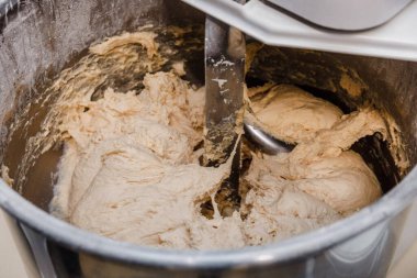 Hamur karıştırıcıyla hamuru karıştırıyor. Hamuru hamurda pişirmek..