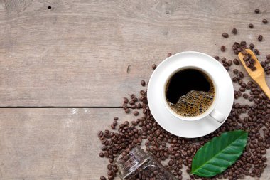 Ahşap zemin üzerinde bir fincan kahve ve fasulye. en üstteki görünüm