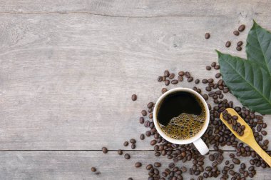 Ahşap zemin üzerinde bir fincan kahve ve fasulye. en üstteki görünüm