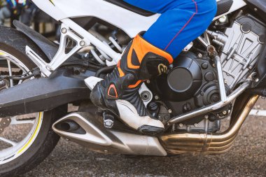 Motorsiklet yarışçısının yakın plan bacağı yumuşak odaklı ve arka planda ışık var.