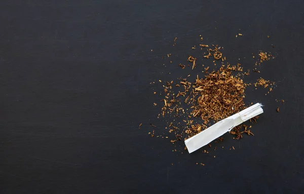 禁烟概念 黑木桌背景上的香烟 顶视图 苍蝇躺在地上 — 图库照片
