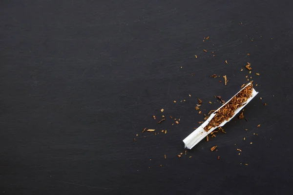 禁烟概念 黑木桌背景上的香烟 顶视图 苍蝇躺在地上 — 图库照片